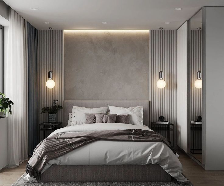 a large bed in a bedroom next to two lamps on the side of the wall