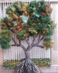 a tree made out of yarn sitting in front of a window