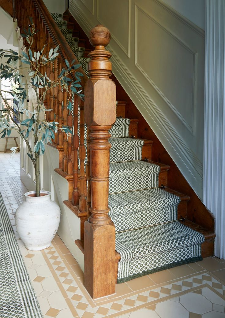 the stairs are made of wood and have green leaves on them, along with a potted plant