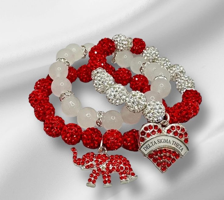 In this COLEction, we proudly present our designs crafted with utmost respect for these beautiful ladies. Each exquisite piece has been hand strung, radiating an enchanting blend of shiny red and white colors, reflecting the timeless crimson and cream symbolism. The 10mm beads, whether made of glass, matte or rhinestone coated clay, exude an air of elegance that perfectly complements these sophisticated ladies. Adorned with dazzling charms, each item becomes a testament to their refined taste an Spiritual Red Stretch Bracelet Gift, Spiritual Red Stretch Bracelet As Gift, Elegant Red Hand-strung Stretch Bracelet, Red Beaded Stretch Bracelet For Valentine's Day, Red Beaded Bracelets For Valentine's Day, Adjustable Red Stretch Bracelet For Valentine's Day, Hand-strung Red Beaded Bracelets For Gift, Hand-strung Red Beaded Bracelets As Gift, Elegant Red Bracelets For Friendship