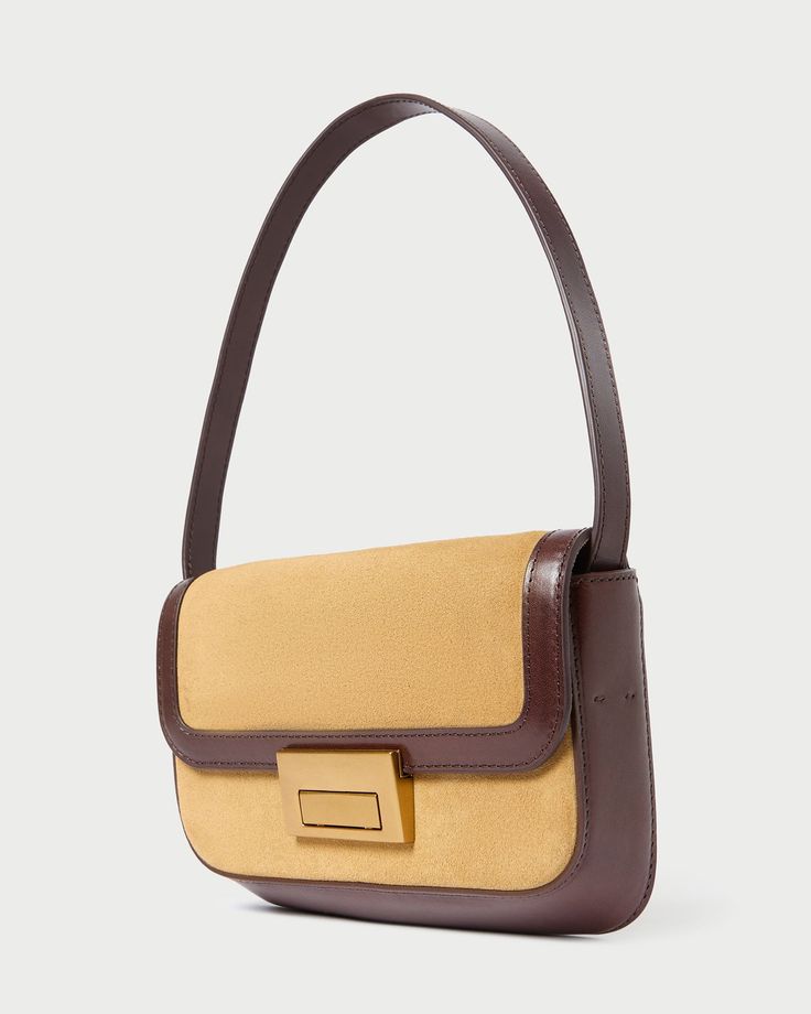 Shoulder baguette bag in hazel tan suede with espresso brown vachetta leather trim. Features slim tonal handles, a push lock closure, full lining, interior zippered pocket, and exterior slip pocket. Luxury Brown Flap Bag With Leather Trim, Modern Brown Flap Bag With Detachable Handle, Brown Top Handle Baguette Bag For Office, Brown Baguette Bag With Detachable Strap For Everyday, Everyday Brown Baguette Bag With Detachable Strap, Everyday Luxury Brown Flap Bag, Timeless Brown Shoulder Bag With Gold-tone Hardware, Timeless Brown Flap Bag For Everyday Use, Travel Baguette Bag With Gold-tone Hardware