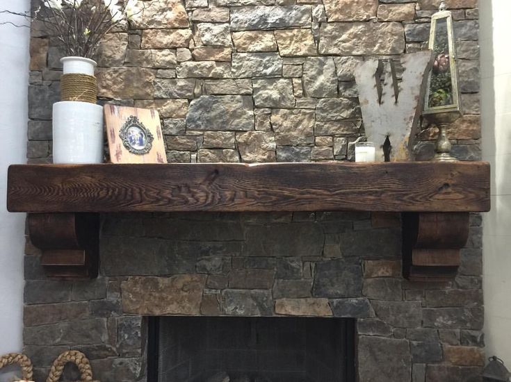 a stone fireplace with wooden mantels and other items on the mantle in front of it