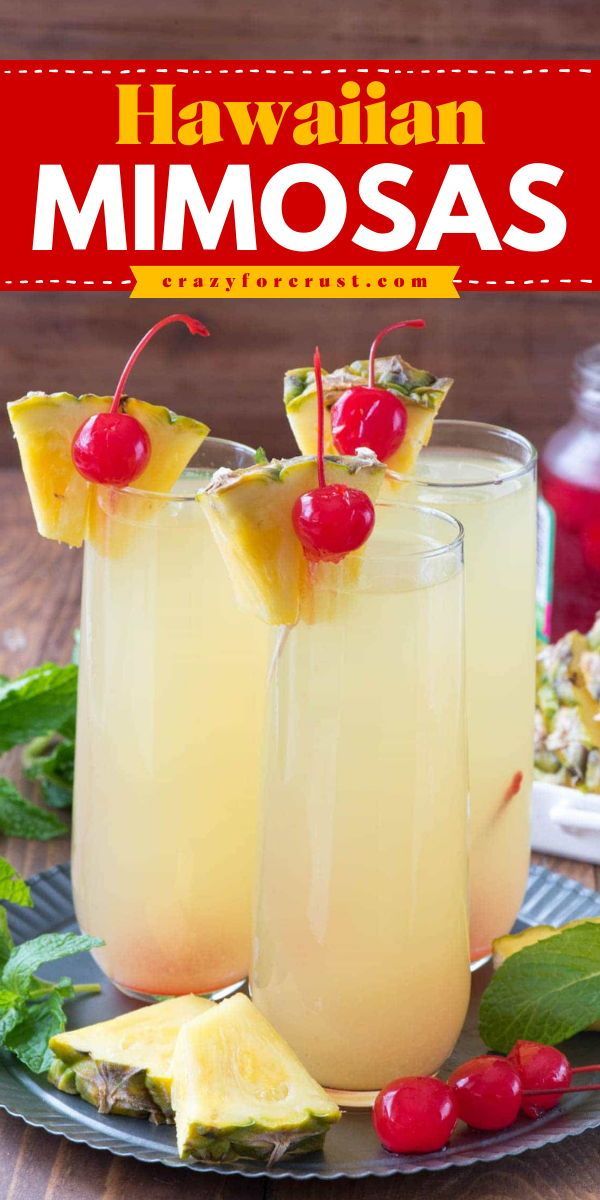 two glasses filled with pineapple mimosa on top of a plate next to other drinks