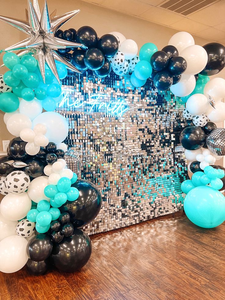 an arch made out of black, white and blue balloons with stars on them for a party