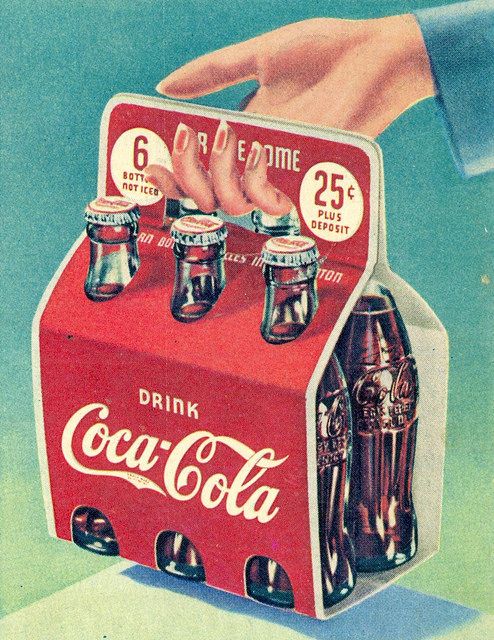 an advertisement for coca - cola in the 1950's shows a hand reaching into a red box with six cans