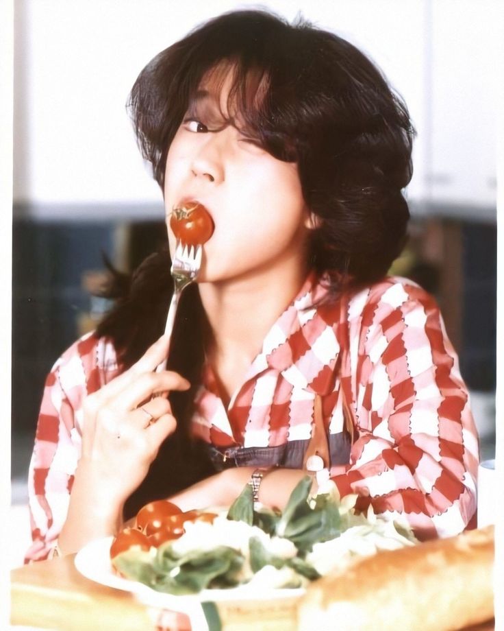 a woman eating food with a fork in her mouth