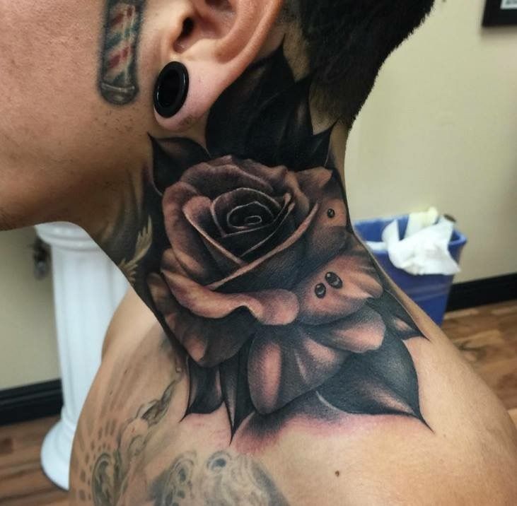 a man with tattoos on his neck and behind the ear is a black rose tattoo