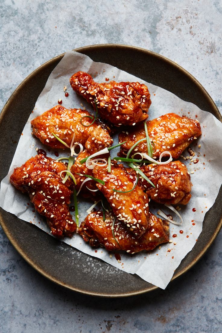 chicken wings with sesame seeds and garnishes on a plate