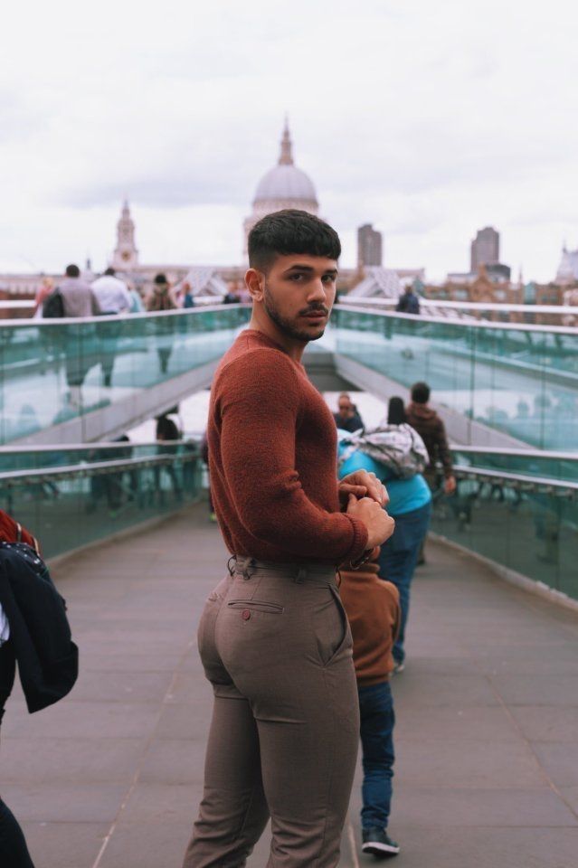 a man standing on top of a bridge next to other people and looking at the camera