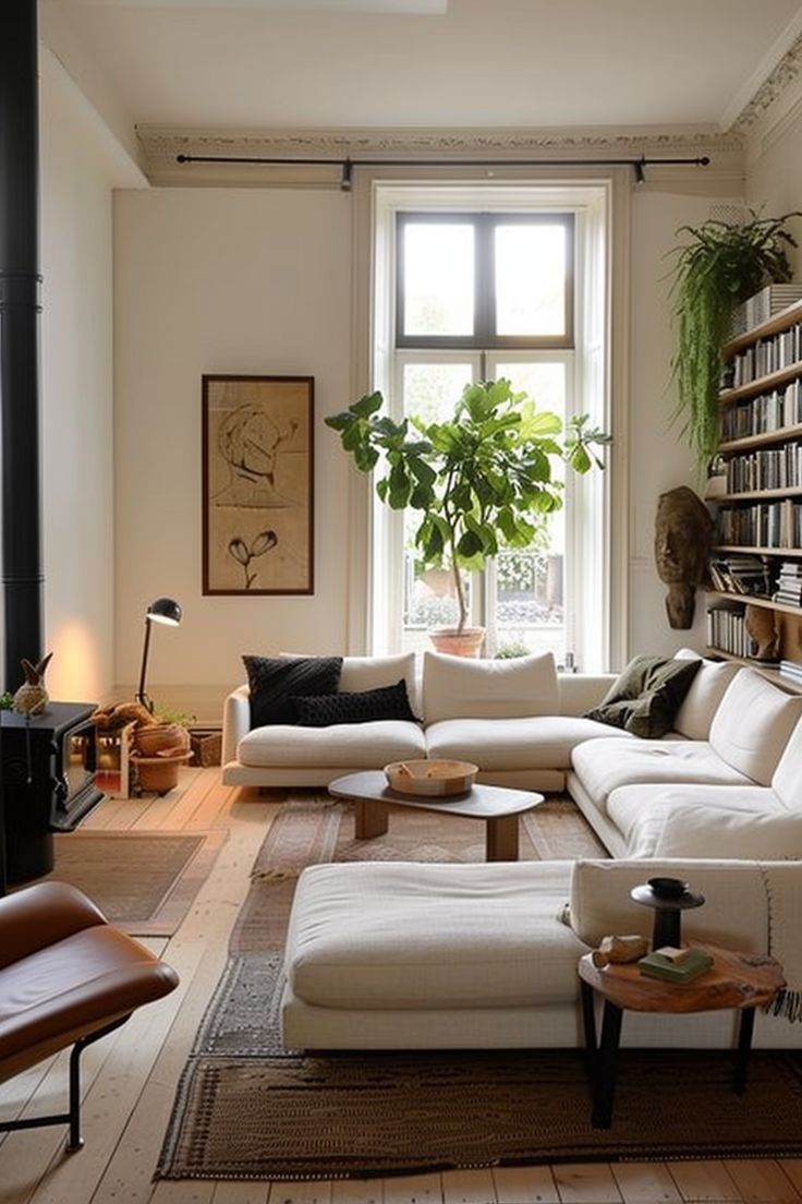 a living room filled with lots of furniture and bookshelves next to a window