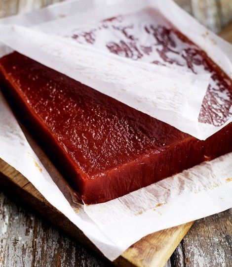 two pieces of meat sitting on top of a wooden cutting board next to each other