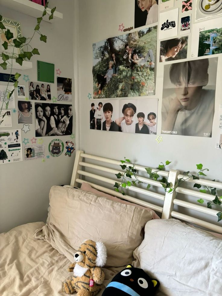 two stuffed animals sitting on top of a bed in a room with pictures and plants