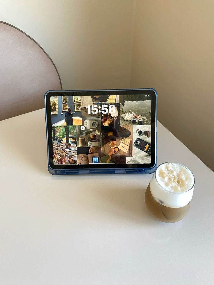 an image of a tablet with pictures on the screen next to a cup of coffee