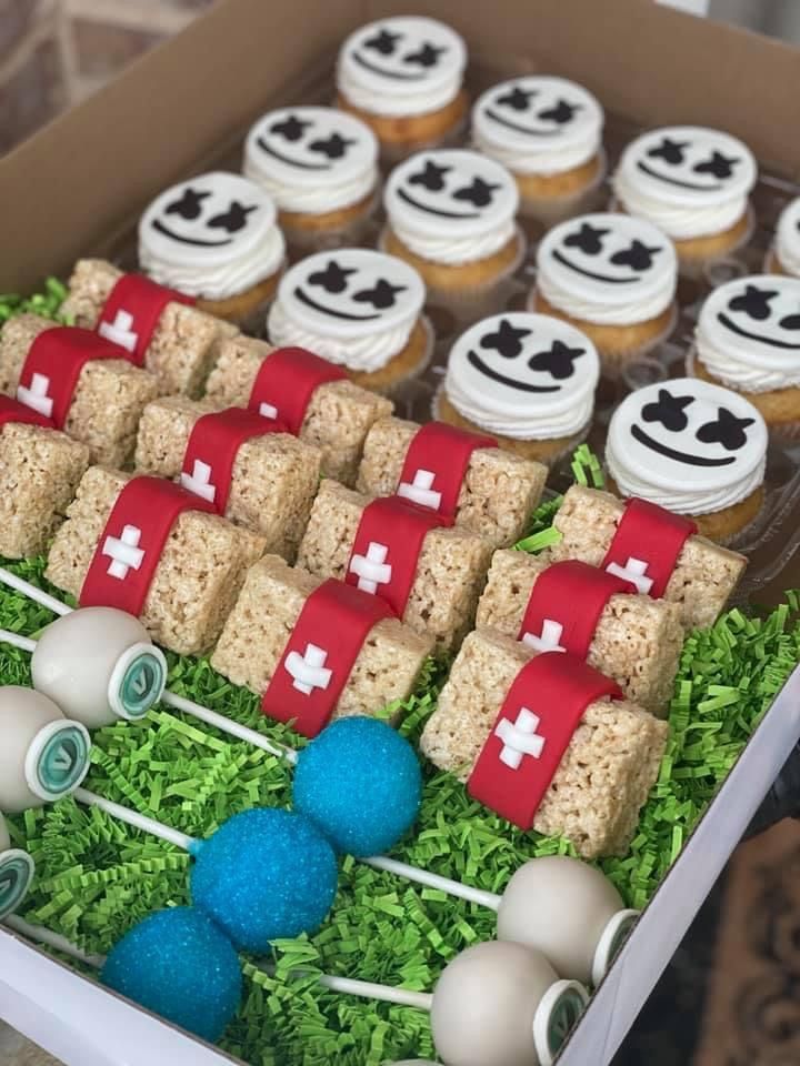 a box filled with cupcakes and marshmallows on top of green grass