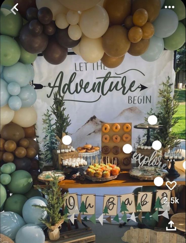 the dessert table is set up with balloons and other decorations for an adventure birthday party