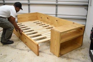 a man working on a bed frame in a garage