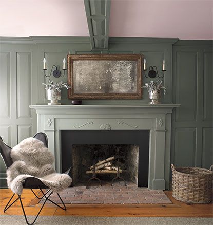 a living room with green walls and a fireplace