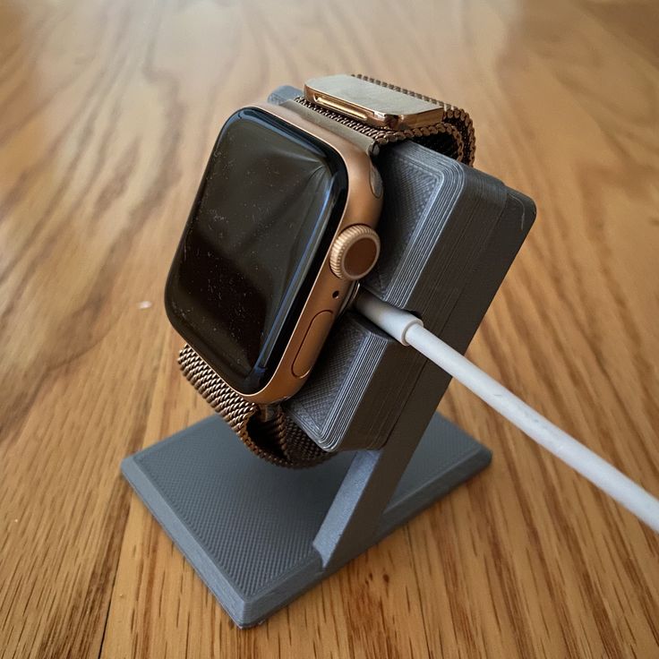 an apple watch is plugged into the charger on top of a wooden table