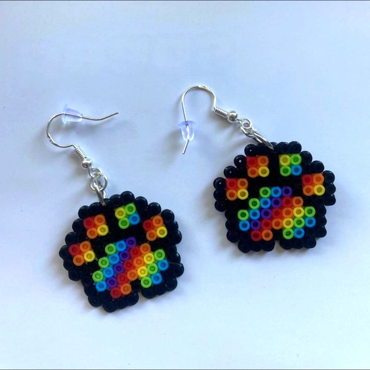 a pair of earrings made out of legos on a white surface with the colors of the rainbow