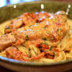 a bowl filled with pasta and meat covered in sauce