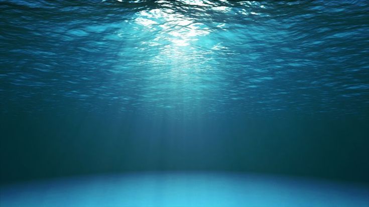 an underwater view of blue water with sunlight shining through the ocean's surface,