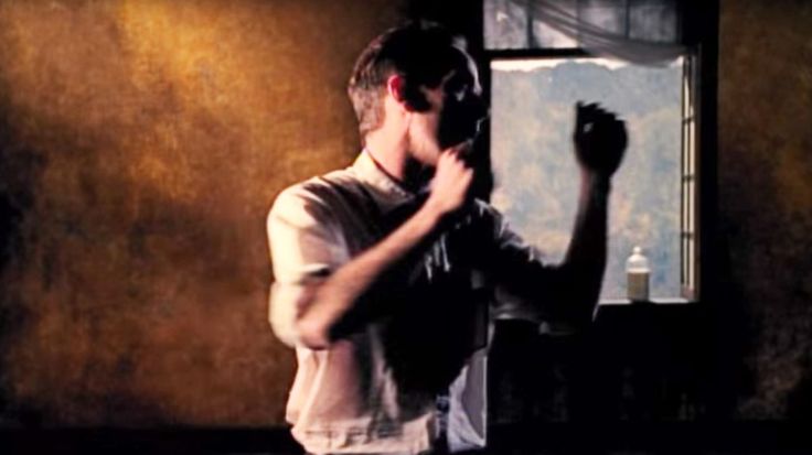 a man standing in front of a mirror with his hand on his face and fist raised