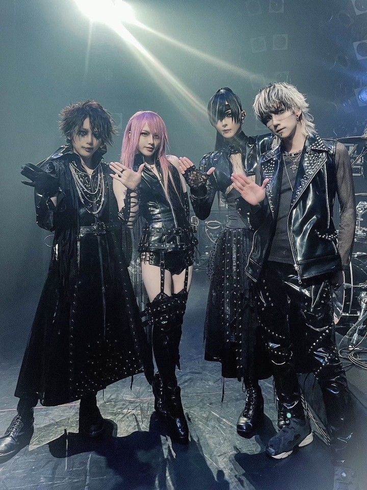 four women dressed in gothic clothing posing for a photo