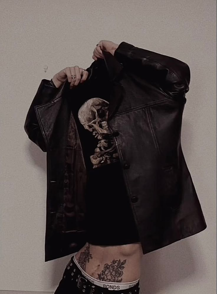 a woman with tattoos holding up a jacket