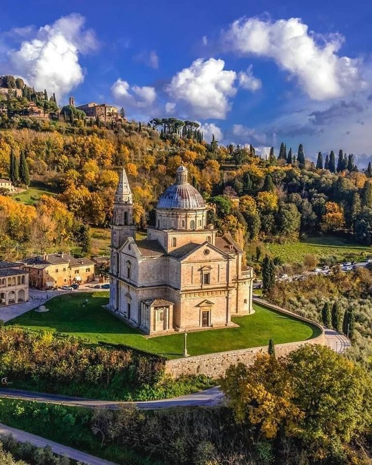 an aerial view of a church in the middle of a field with trees around it