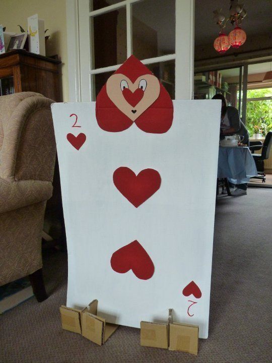 a white sign with red hearts on it in front of a couch and chair,