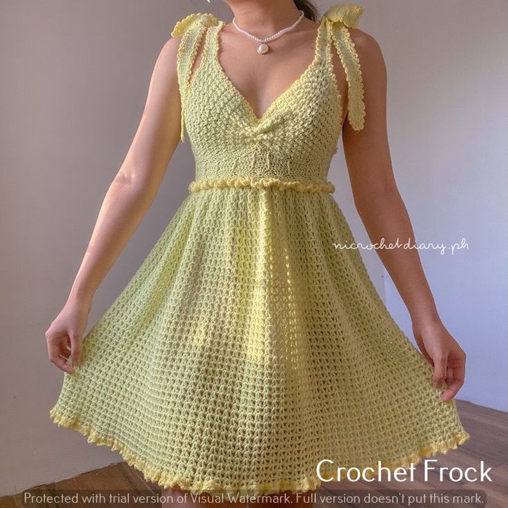 a woman wearing a yellow crochet dress and pearls is posing for the camera