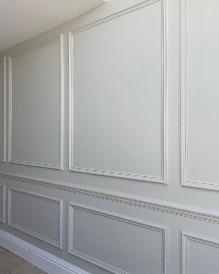 an empty room with white paneling on the walls