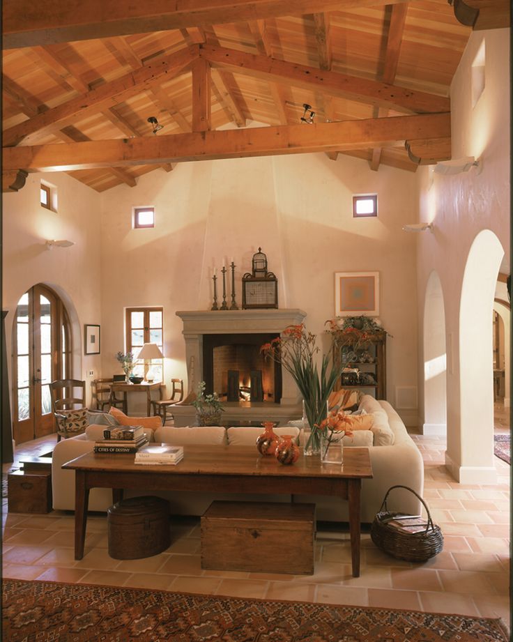 a living room with a couch, table and fireplace inside of it on top of tile flooring