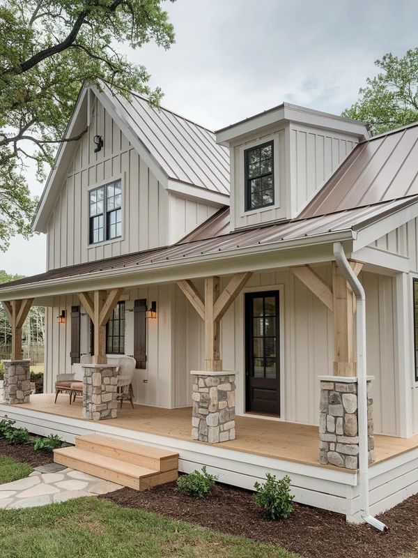 a white house with a porch and stone pillars