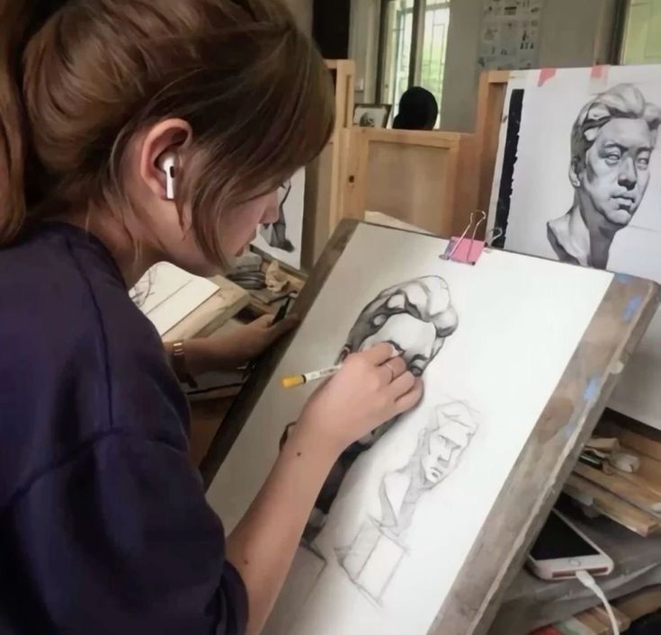 a woman is drawing on a canvas in an art studio with her head turned to the side