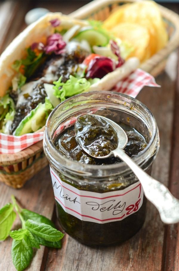 a jar filled with pickled vegetables next to a basket full of salad