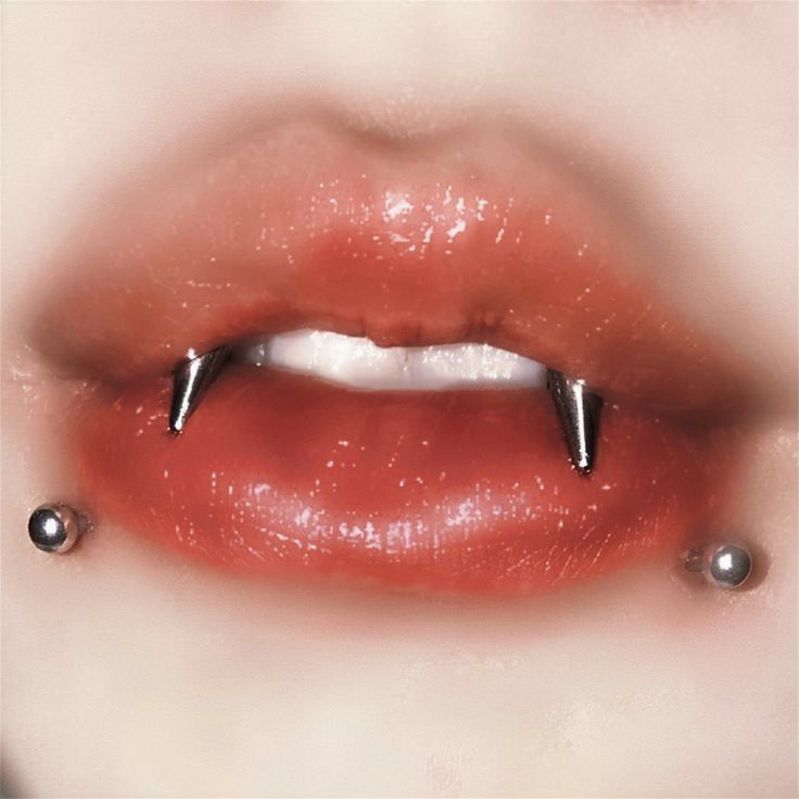 a woman's lips with piercings on them