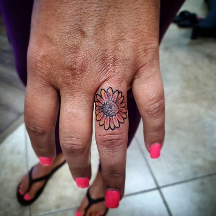 a woman's hand with a flower tattoo on it