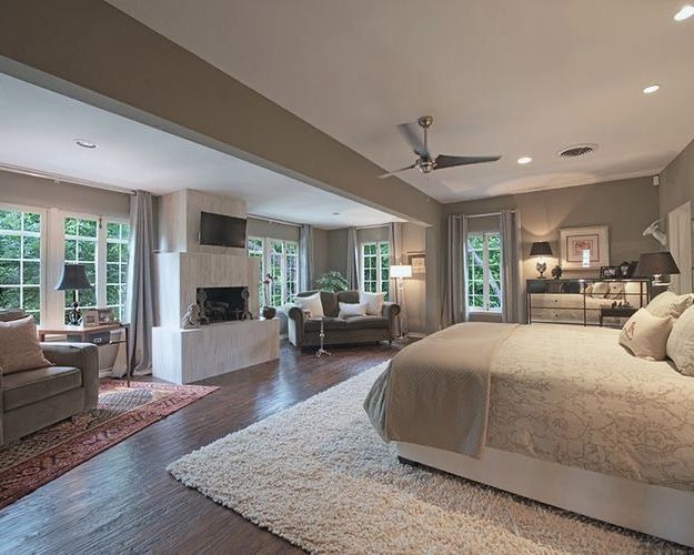 a large bed sitting inside of a bedroom on top of a hard wood floored floor