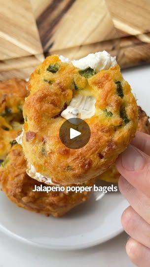 someone is holding up some food on a plate with the words jalapeno popper bagels