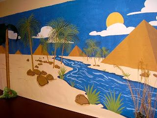 a mural on the side of a building with palm trees and mountains painted on it