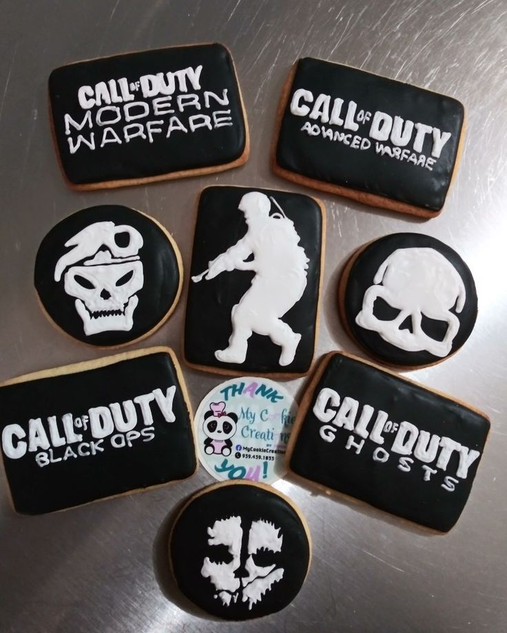 six decorated cookies with the words call of duty and skull heads on them, all in black and white