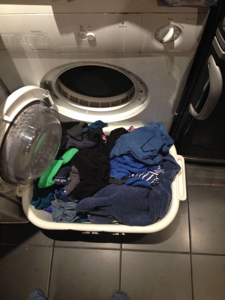 a washing machine filled with clothes on top of a tiled floor