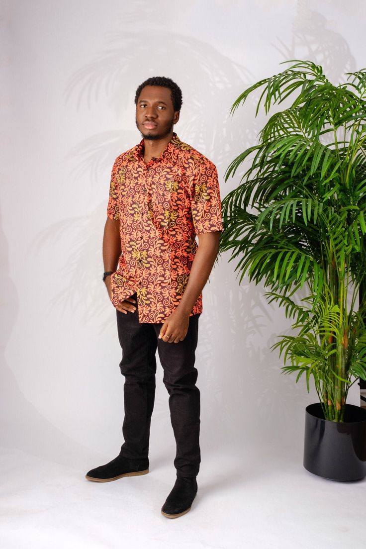 This soft and lightweight African print (Ankara)  men's shirt is perfect for summer. It is made of cotton and has a classic button down collar. The bright color will match with any outfit which makes it perfect for a night out on the town, a special occasion, casual wear or work.  The Shirt is named after the street style dance from Nigeria; Shoki Short sleeves  100% Ankara wax cotton (exclusive of ornamentation) One breast pocket  Patrick is 5'9" and wearing size XL Handmade in Nigeria Orange Cotton Hawaiian Shirt For Summer, Orange Cotton Shirt With Print, Orange Cotton Camp Shirt For Summer, Patterned Cotton Shirt For Summer, Orange Cotton Shirt With Button Closure, Orange Relaxed Fit Cotton Camp Shirt, Orange Button Closure Shirt For Summer, Summer Patterned Button-up Shirt, Orange Cotton Summer Shirt