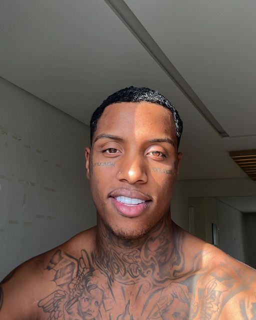 a man with tattoos on his chest is looking at the camera while he's taking a selfie