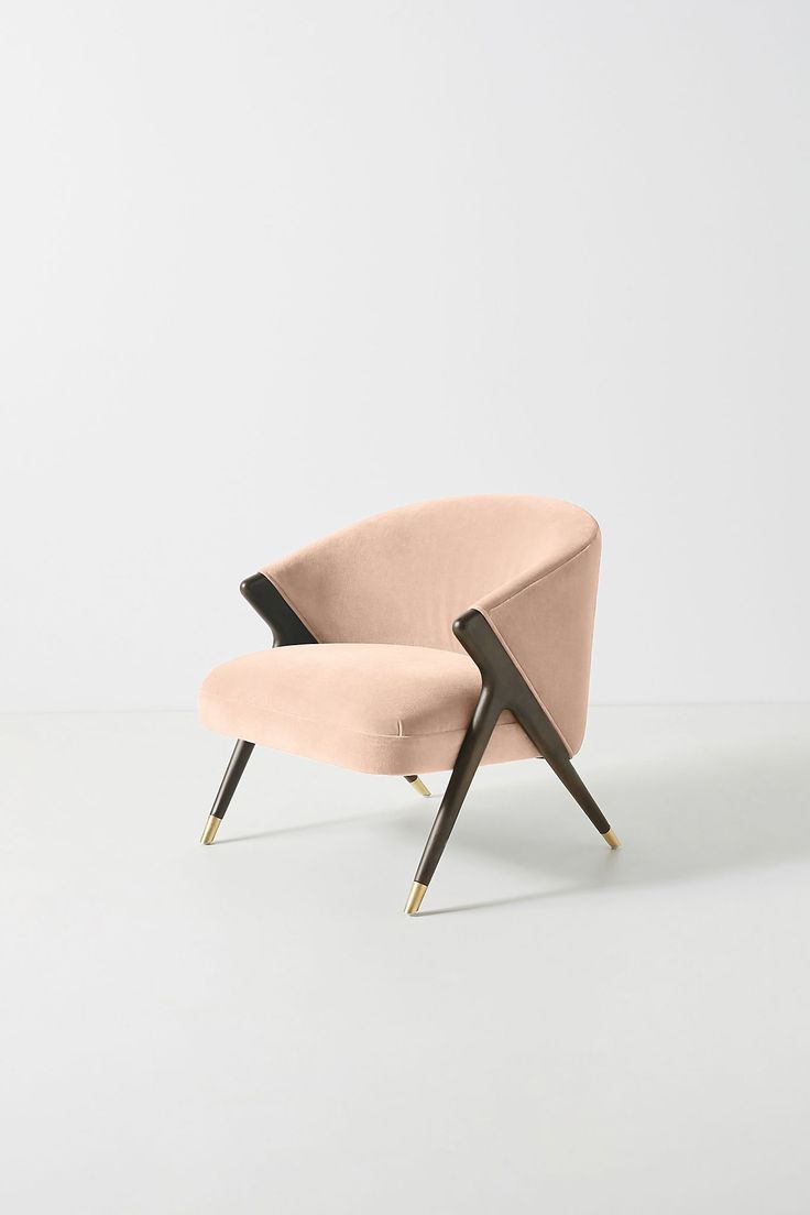 an upholstered pink chair with black legs