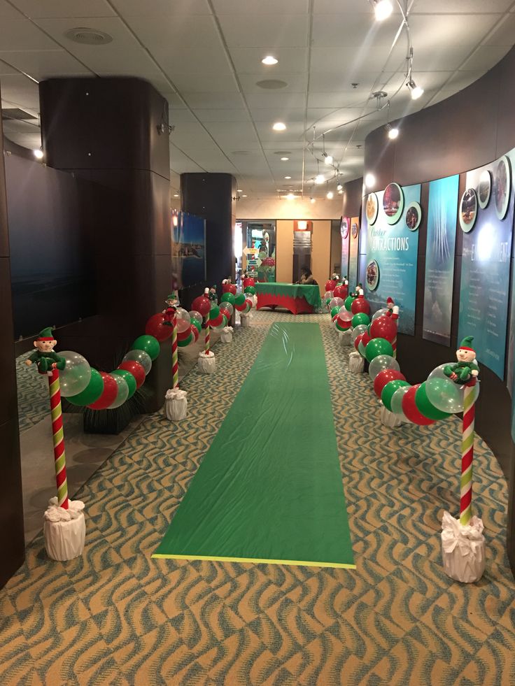 an indoor golf course decorated for christmas with candy canes on the green and red poles