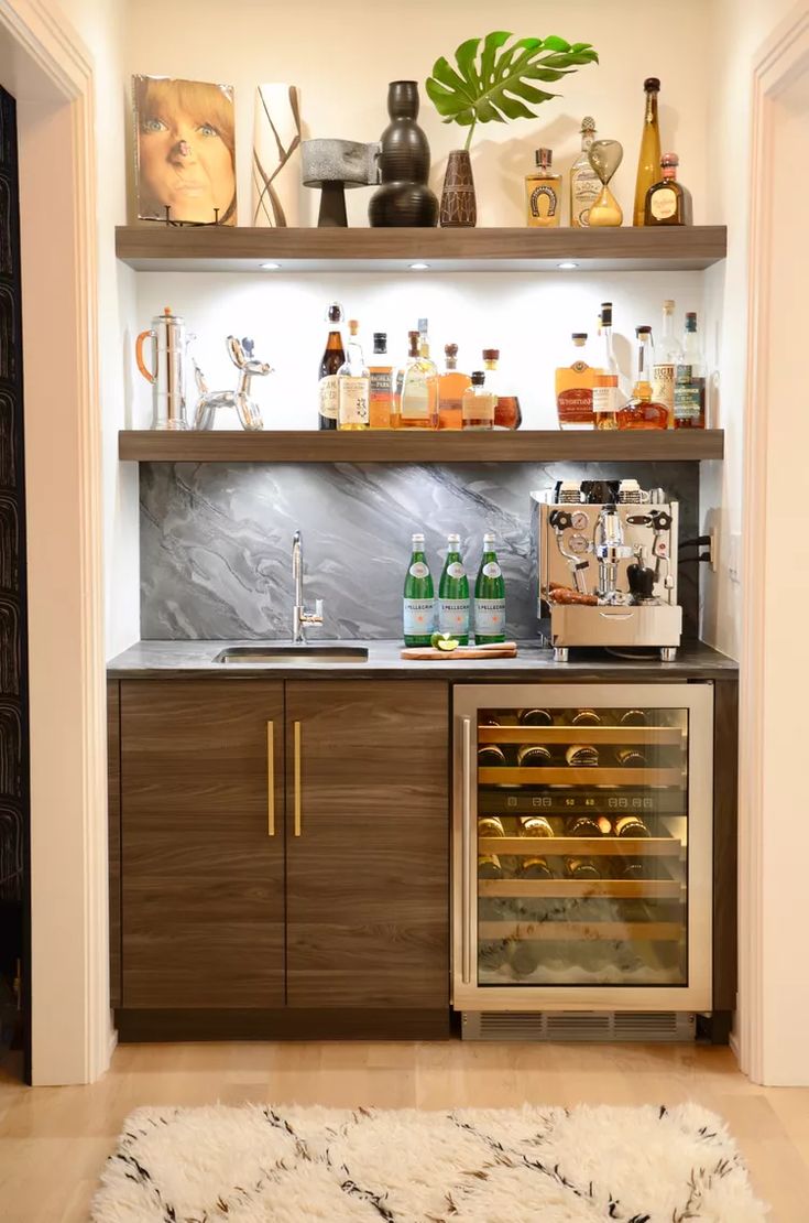 a kitchen with shelves filled with bottles and glasses on top of the counter, next to a rug