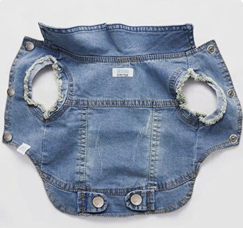 a blue jean jacket with holes in the back