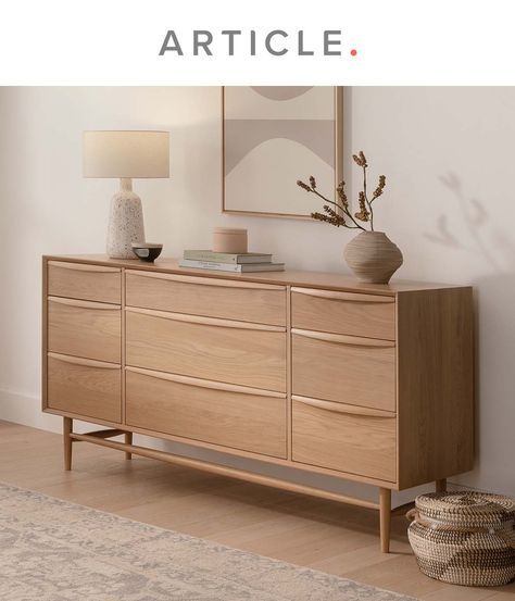 a wooden dresser sitting on top of a hard wood floor next to a white wall